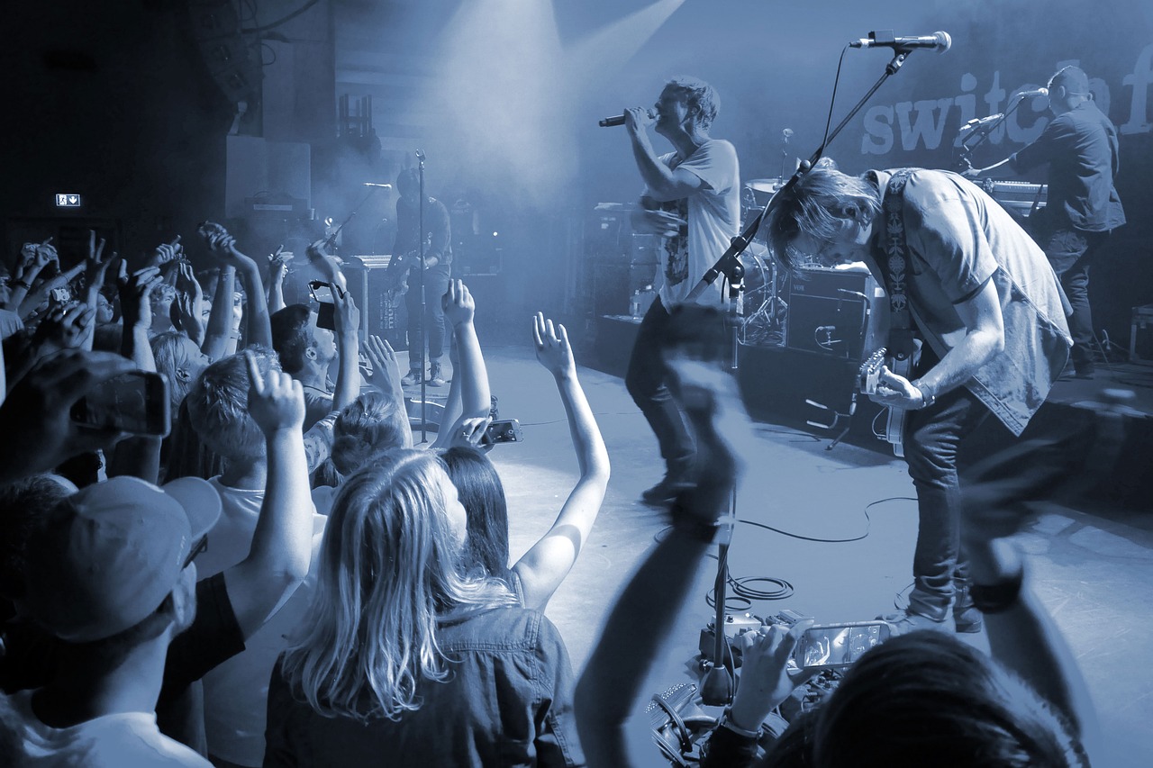 Band playing to a packed room with hands in the air